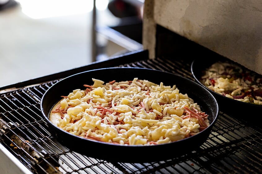 A pizza going into the oven